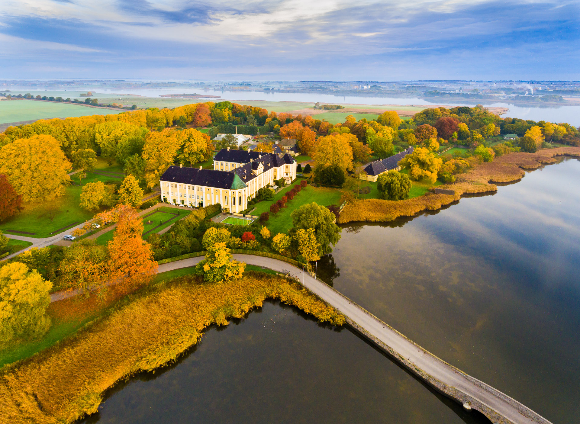 Dronefoto af Gavnø Slot iklædt de msukkeste efterårsfarver.